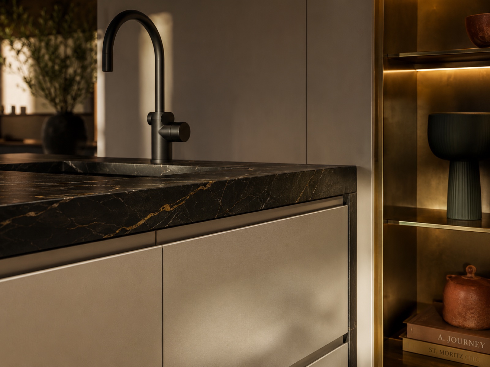 Détail de cuisine sur-mesure avec robinet noir, marbre et éclairage intégré